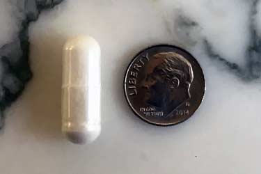 500 mg capsule next to dime to show size