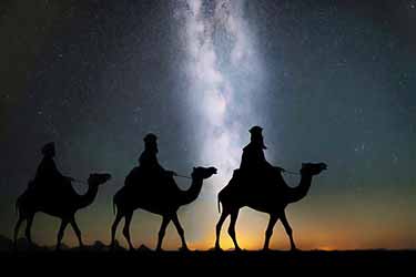 Biblical magi on camels during starry night