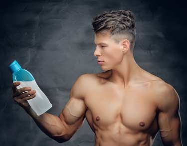 young buff bodybuilder holding protein drink