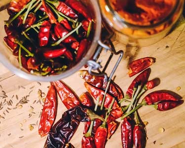 fresh and dry red chili peppers on cutting board