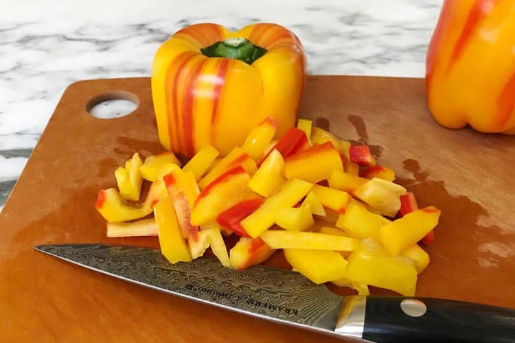 fresh striped pepper diced on cutting board