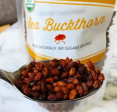 dried buckthorn berries on spoon