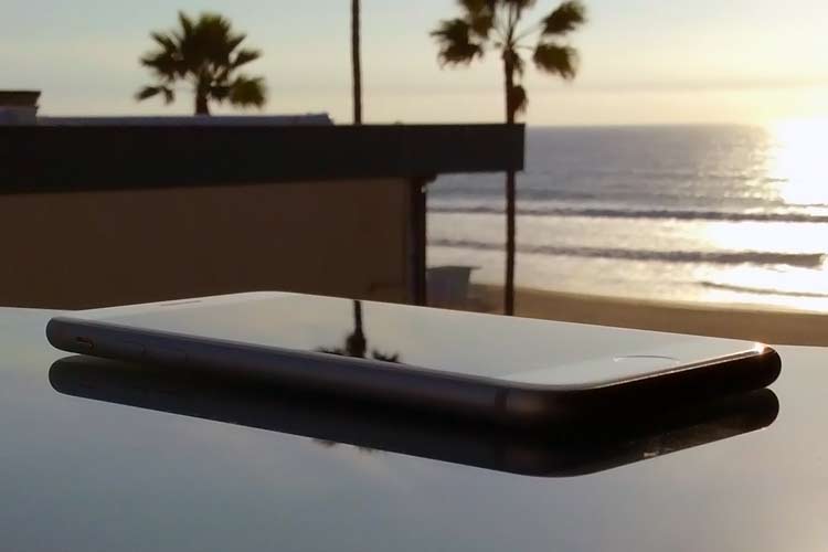 iPhone on desk in front of ocean sunset