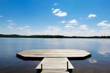 dock on calm lake with sunny blue sky