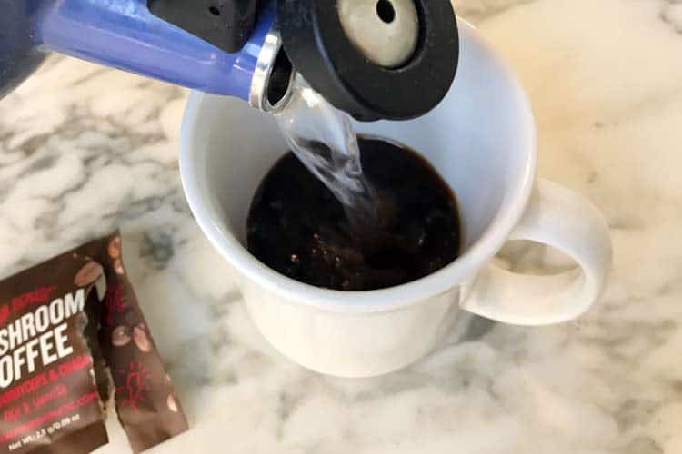 pouring hot water into coffee with mushroom powder