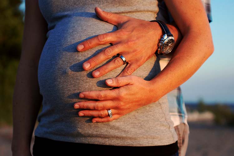 pregnant woman with husband holding tummy