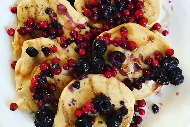 plate of pancakes topped with berries