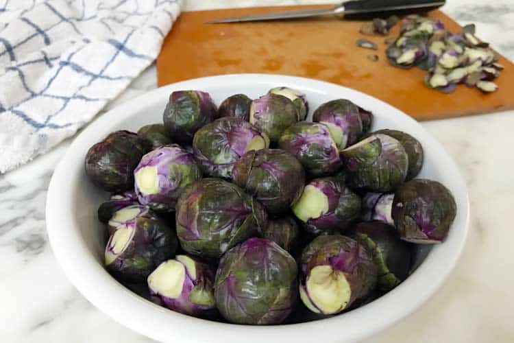 bowl of raw purple Brussels ready to bake, boil, fry, grill or roast