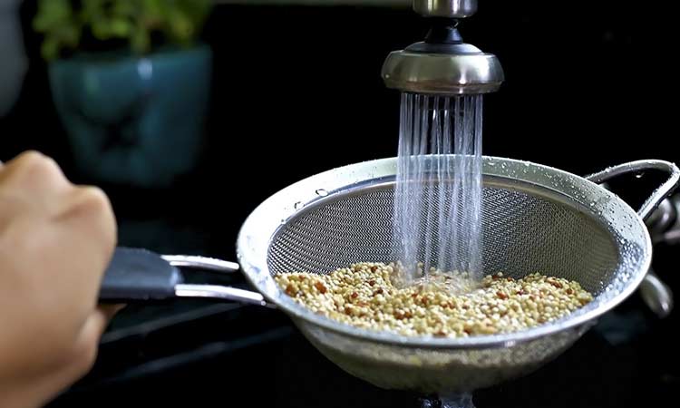 rinsing quinoa in sink using strainer