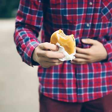 man with stomach ache from eating burger