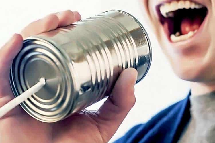 man yelling into tin can phone