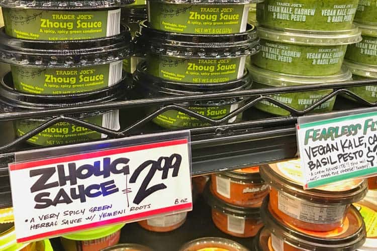 Trader Joe's zhoug sauce next to vegan pesto on shelf